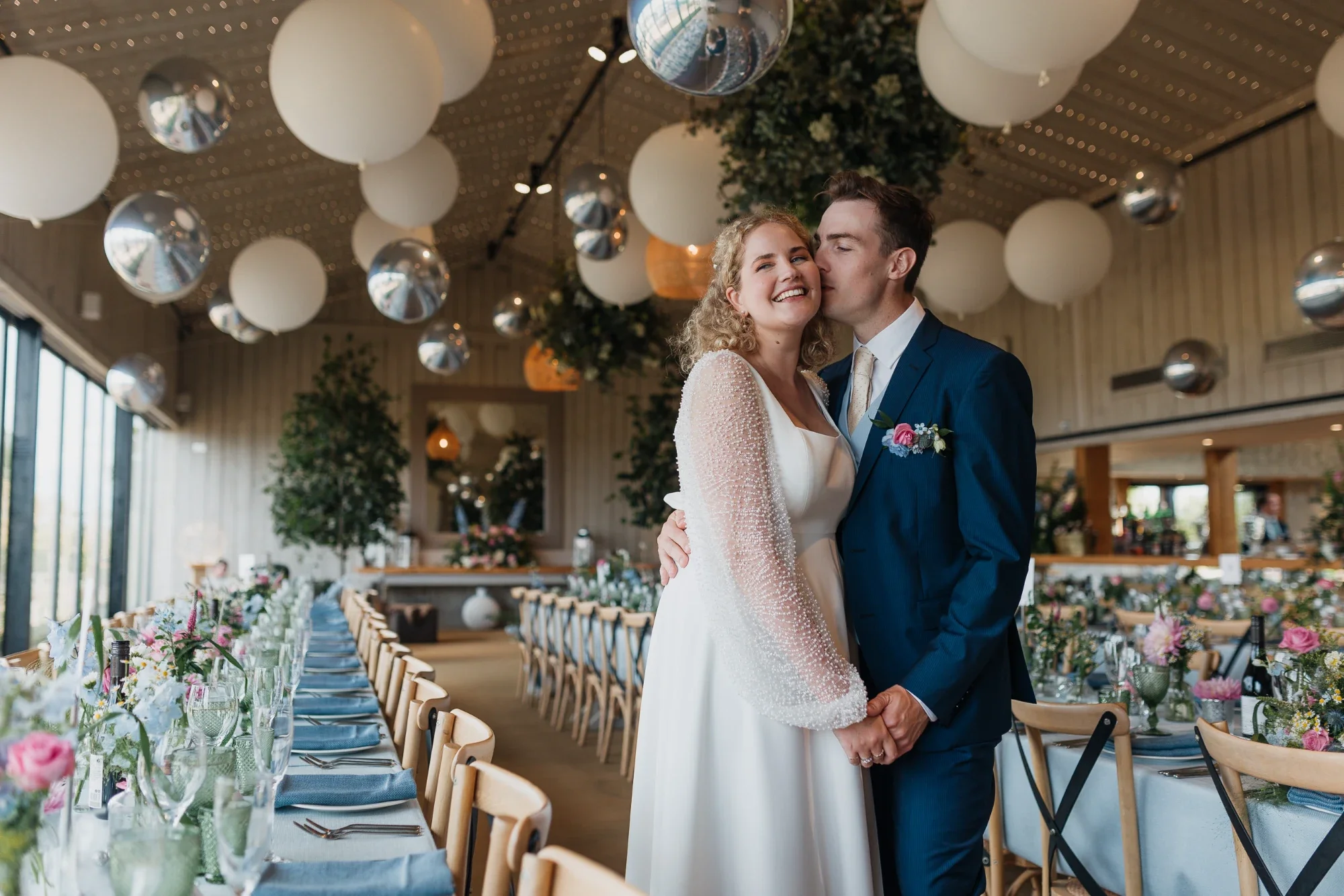 Custom ivory crepe wedding dress with an oversized bow train and sparkly bubble sleeves