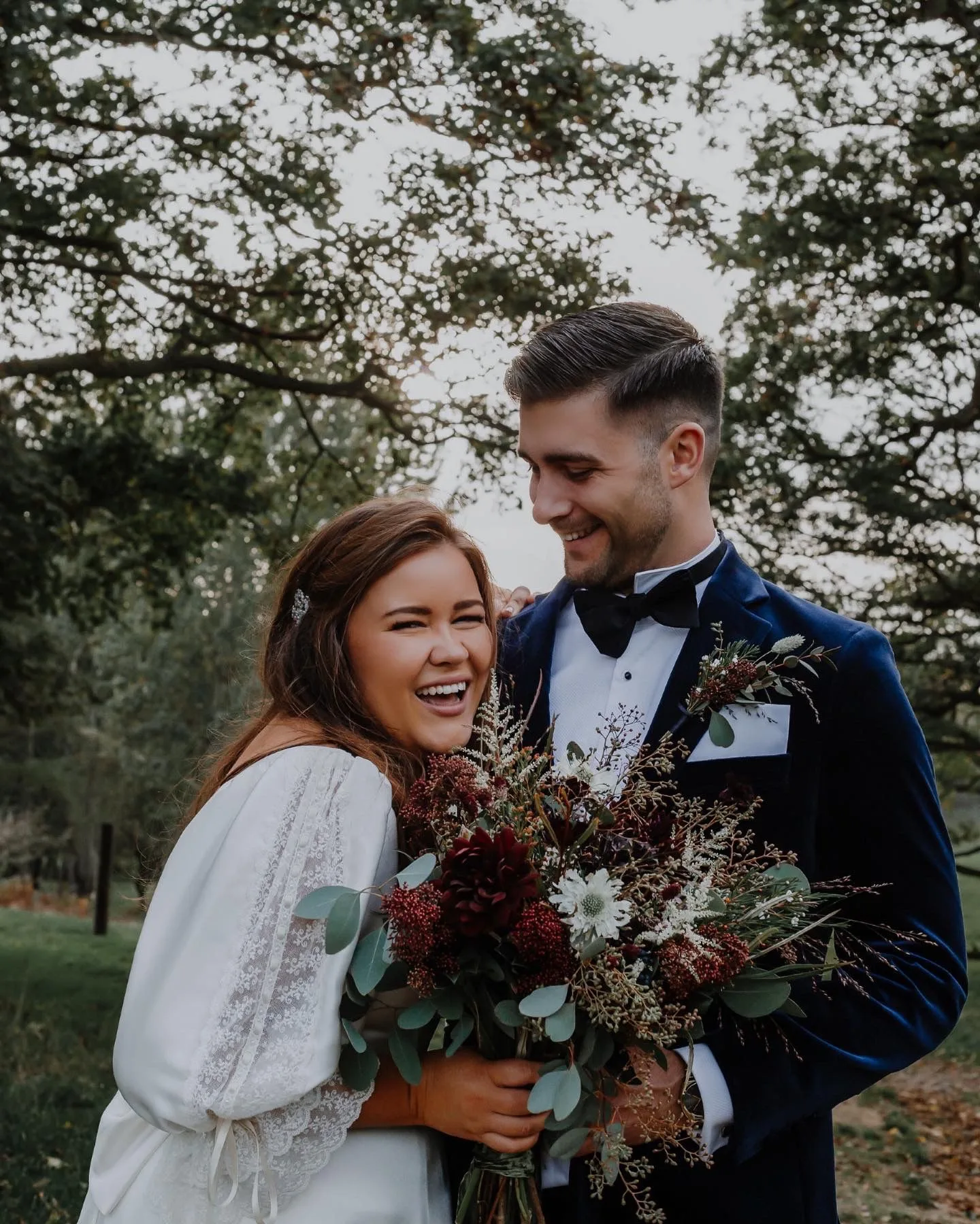 Custom silk A-line wedding dress with built-in corsetry and vintage lace sleeves from the bride's mother's dress